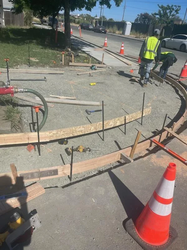 Concrete driveway project with rebar reinforcement, formwork, and crew working on-site