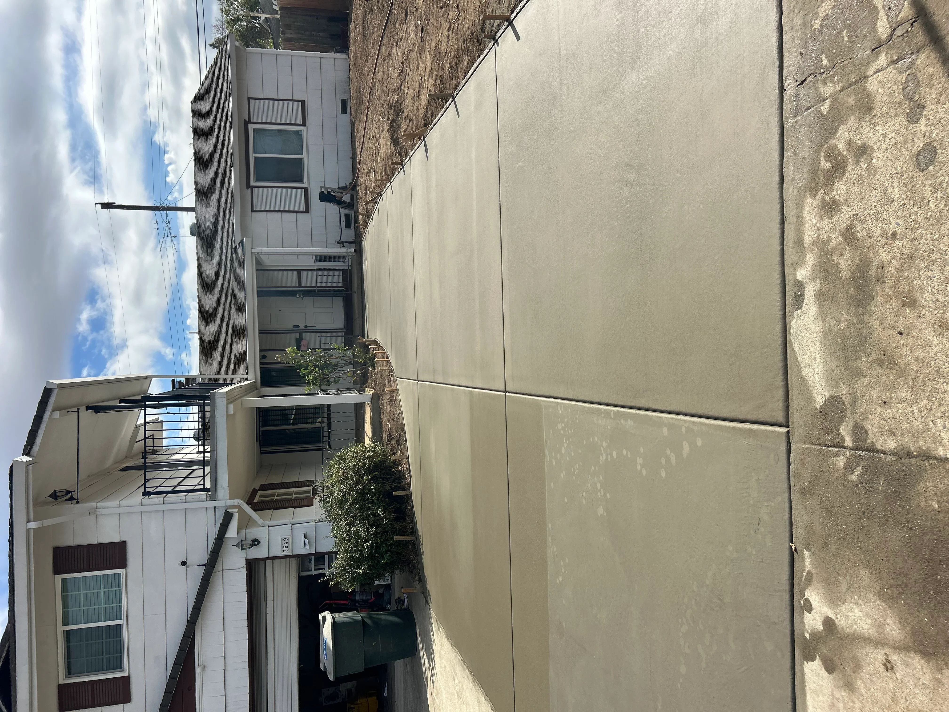 Newly installed concrete driveway with finished panels between residential buildings