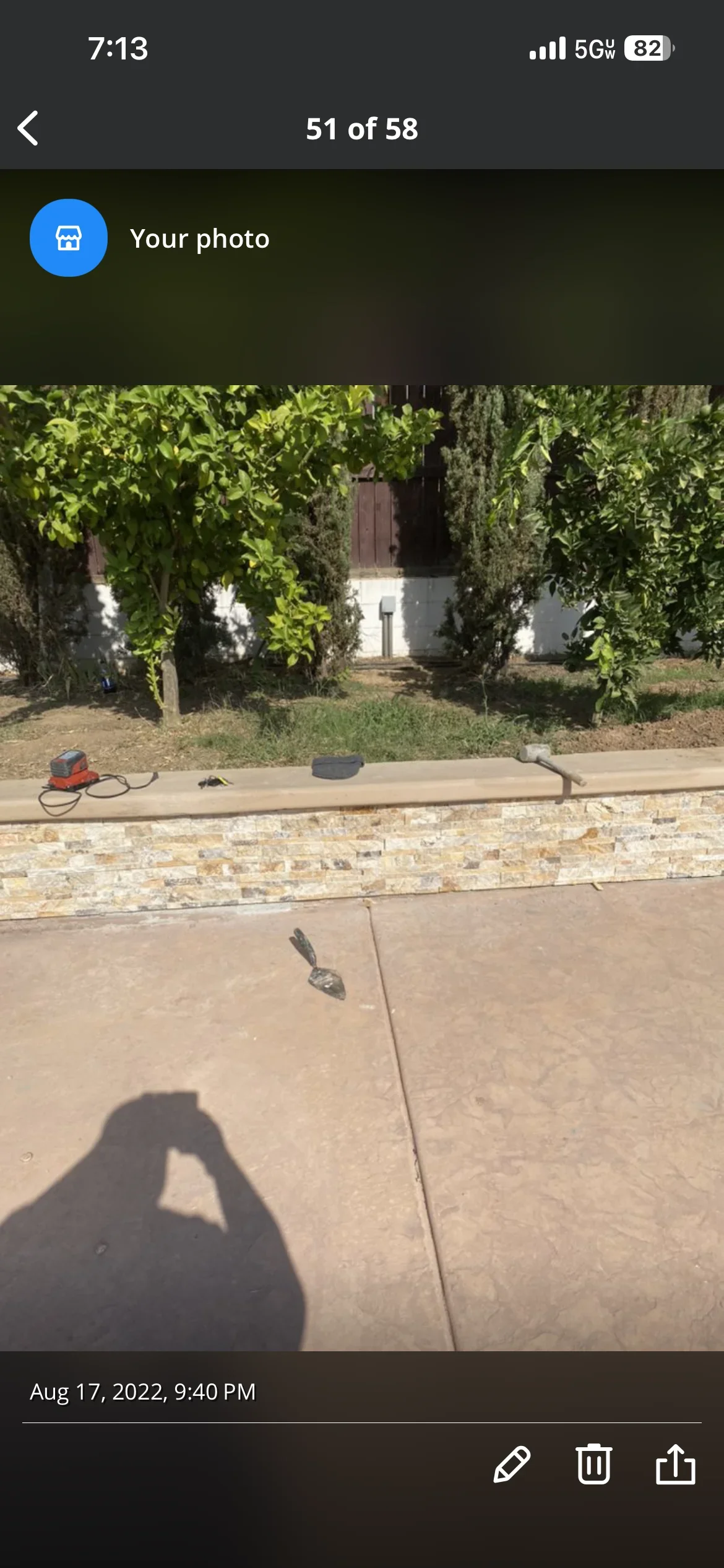 Finished concrete patio with stone retaining wall and manicured landscaping