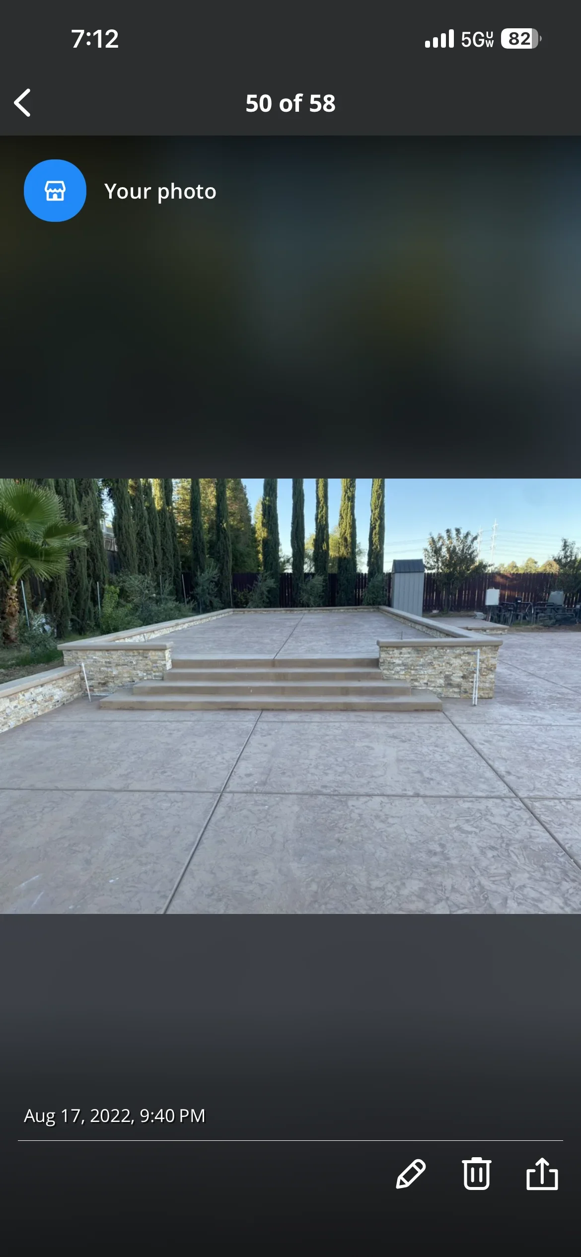Stamped concrete patio with stone pillars and wooden steps in Sacramento backyard