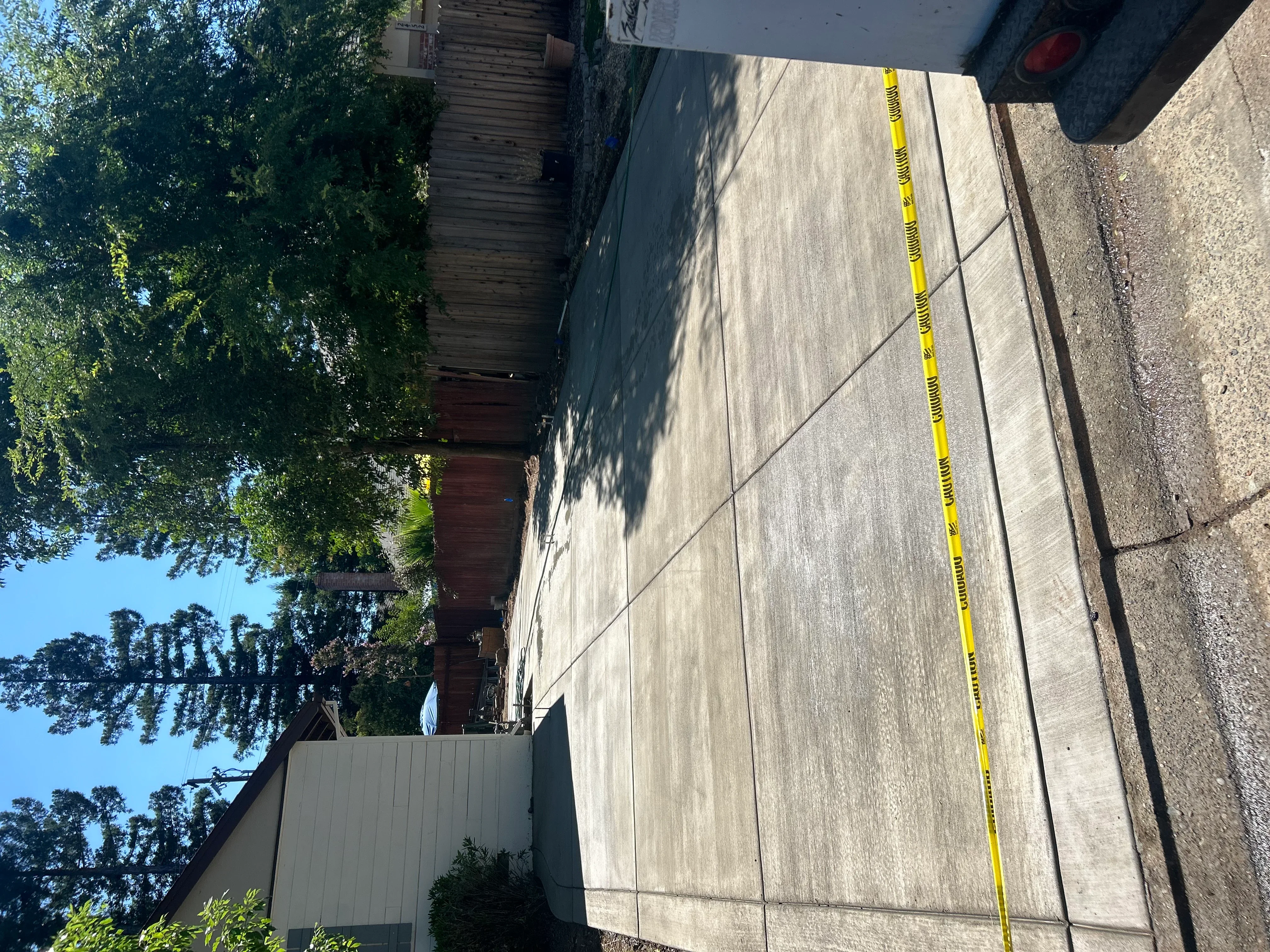 New concrete driveway with control joints and yellow measurement tape during installation