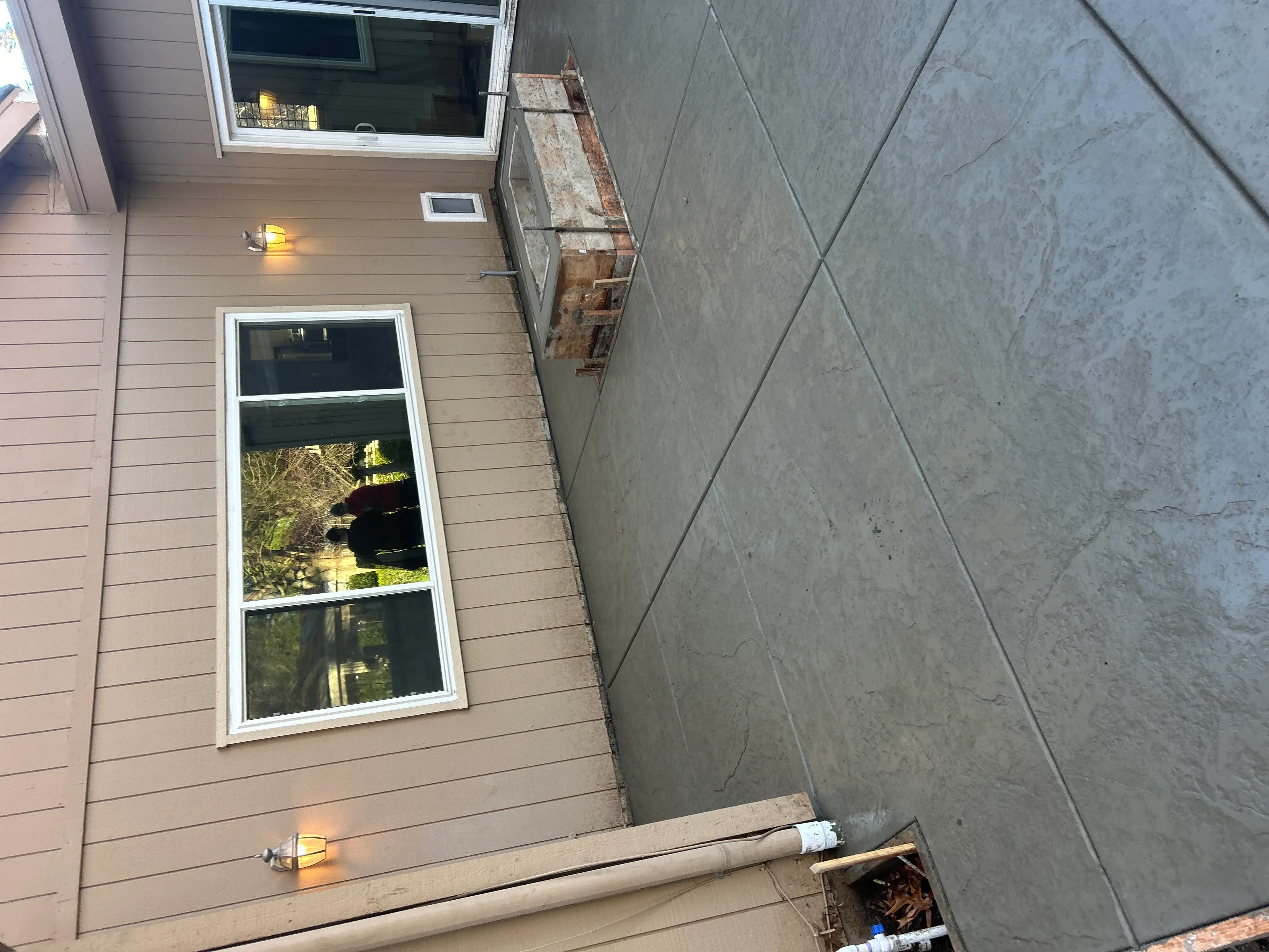 Newly installed concrete driveway with control joints and residential home exterior