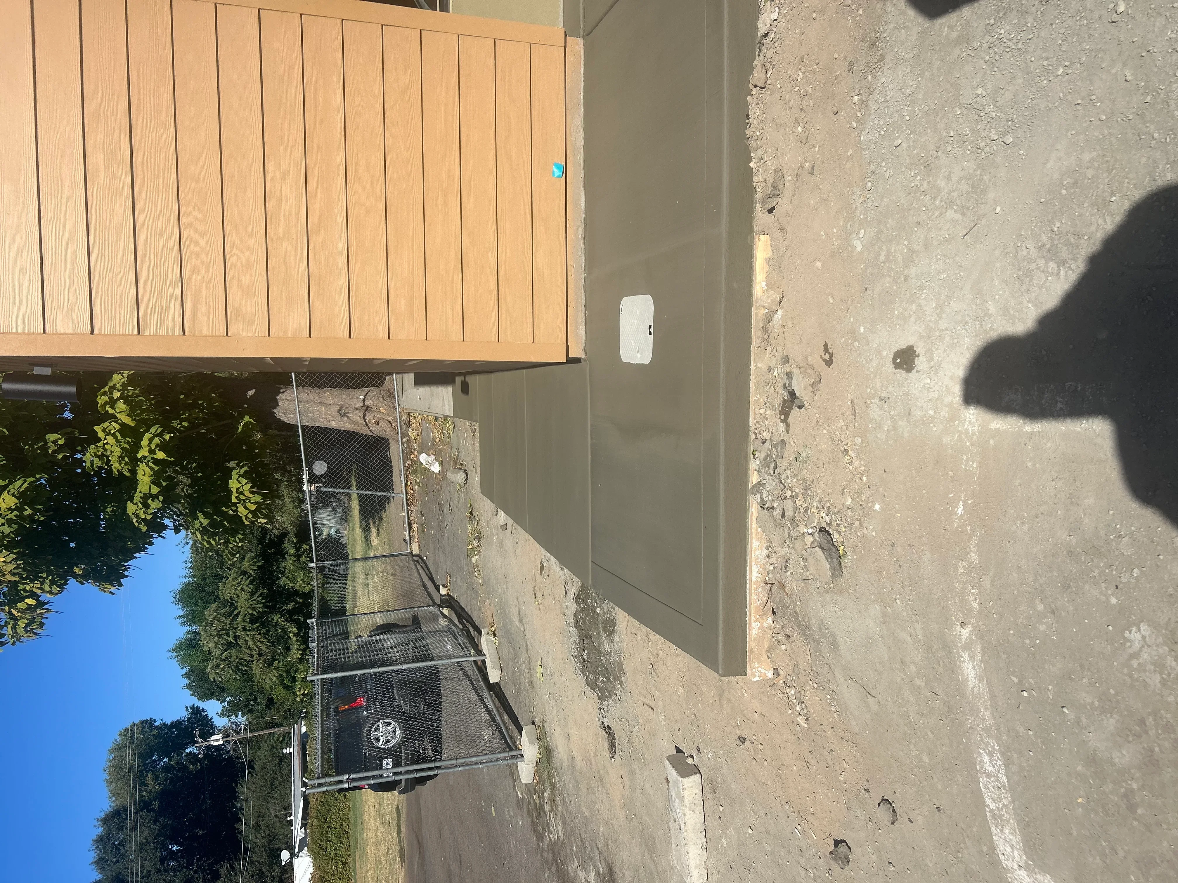 Newly poured concrete driveway with finished surface and metal utility stairs