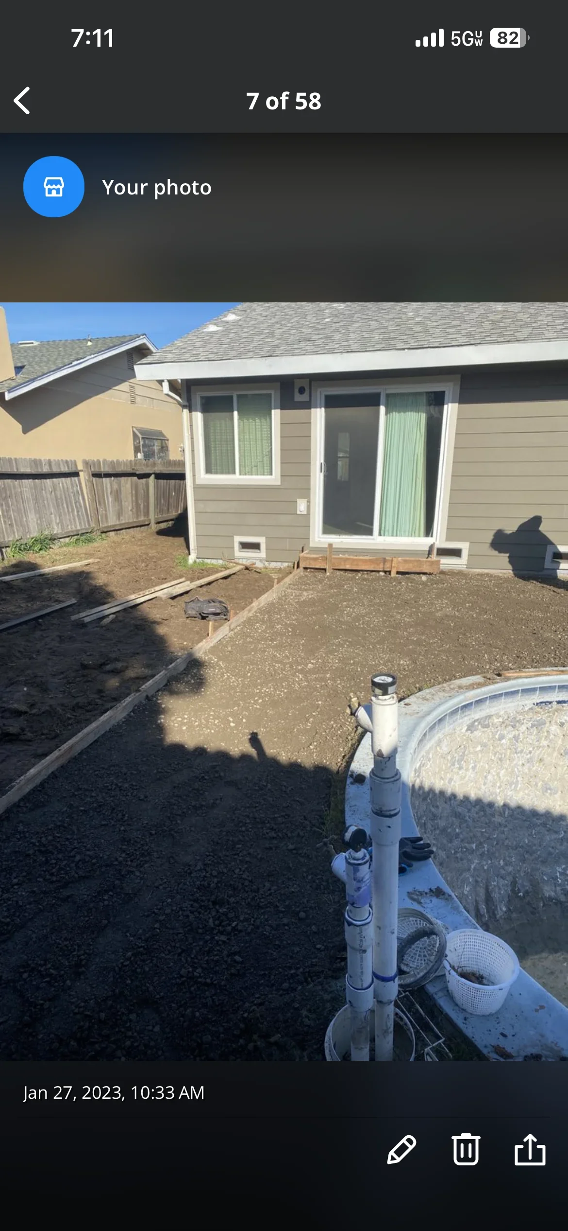 Newly poured concrete patio with pump equipment and wooden forms in residential backyard