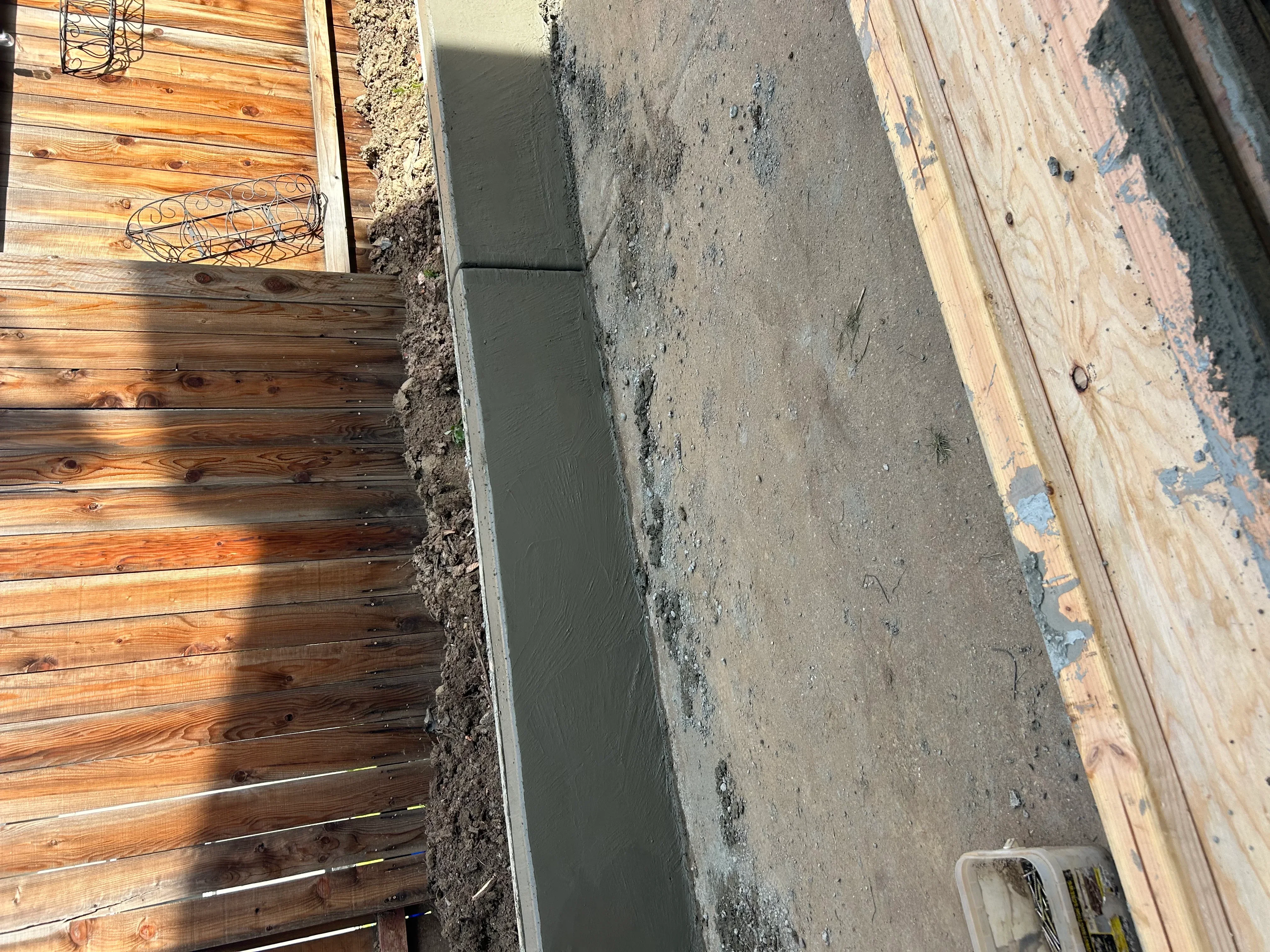 Freshly poured concrete foundation with wooden forms and framing during construction