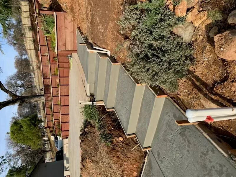 Concrete retaining wall with segmented panels on sloped residential property