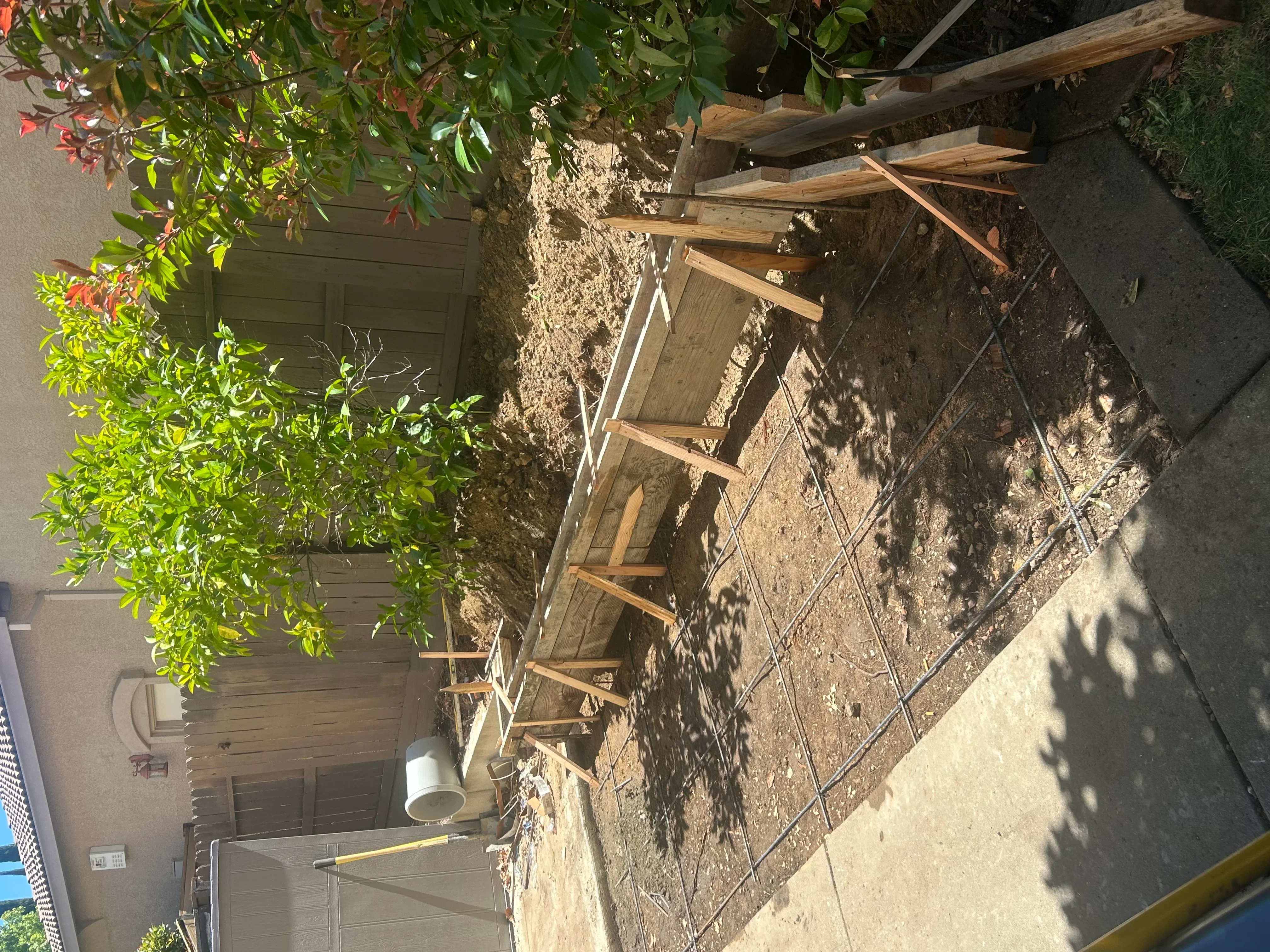 Concrete foundation repair with steel rebar and wooden support bracing